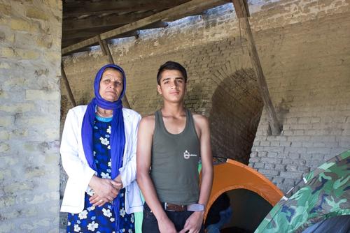 Haseeb, 13, and his mother Zubida stand amongst refugees’ abandoned tents in the old brick factory in Subotica, Serbia. Photo: Ilija Gudnitz Weber/MSF