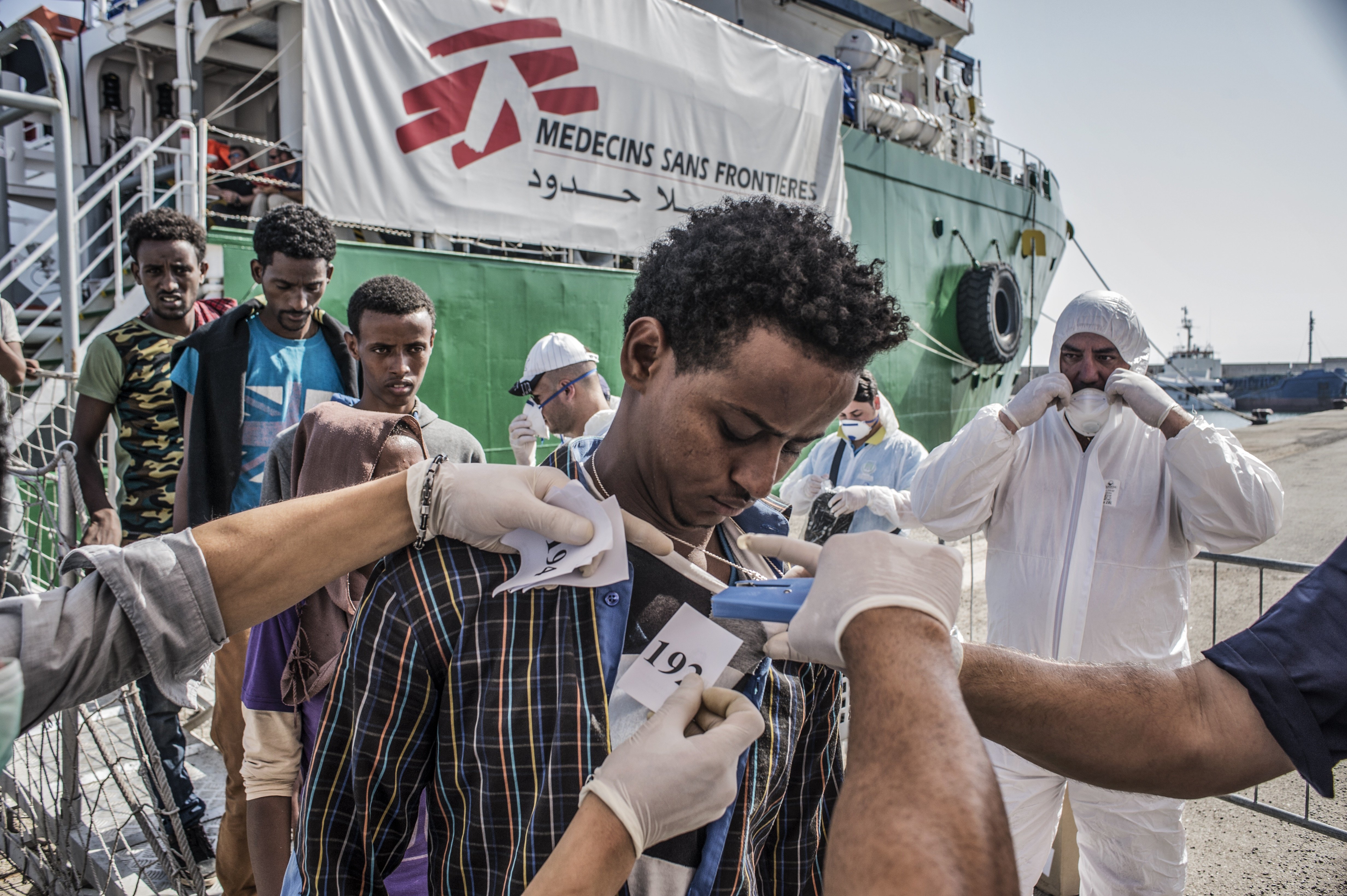 A refugee is numbered by the Italian authorities as people disembark the Bourbon Argos in Vibo Valentina, Calabria, Italy and queue to be registered. Photographer: Francesco Zizola
