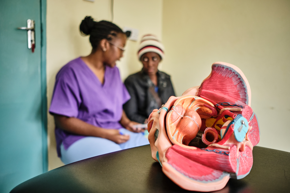 A MSF doctor from the women's health, cervical cancer project in Malawi, talks with a patient who has just returned from Kenya for radiotherapy.