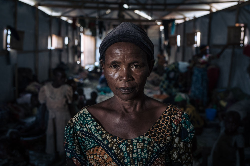 Agrippine, a 53-year-old displaced widow, poses for a photograph in a community shelter at the informal IDP site of Rugabo Stadium in Rutshuru Centre, in North Kivu province, eastern Democratic Republic of Congo. She and six of her ten children fled their village because of clashes between the Congolese army and the M23 armed group. She has no news of her other four children.