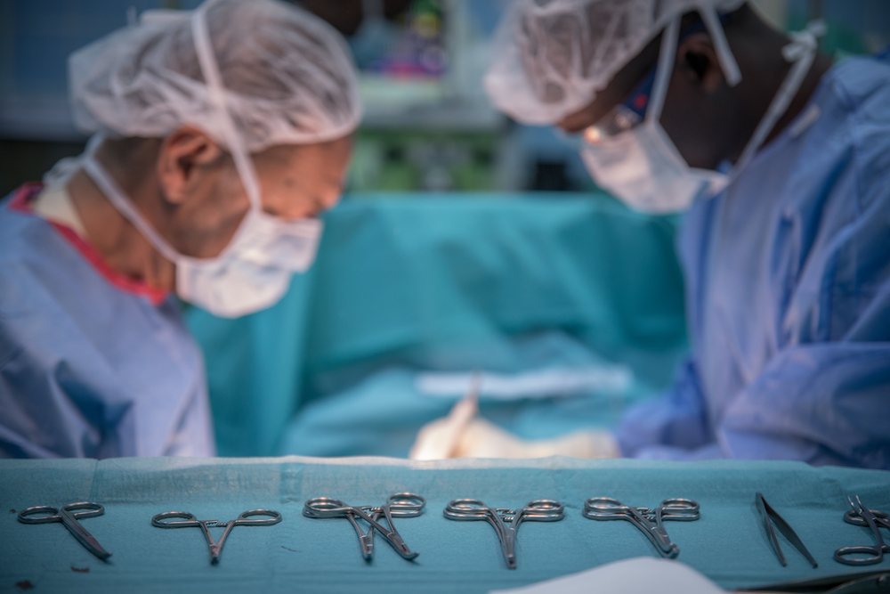 Dr Rosso, MSF surgeon, and Mickael, MSF OT nurse, during the surgery debridement of a 2 years old boy victim of severe malaria.