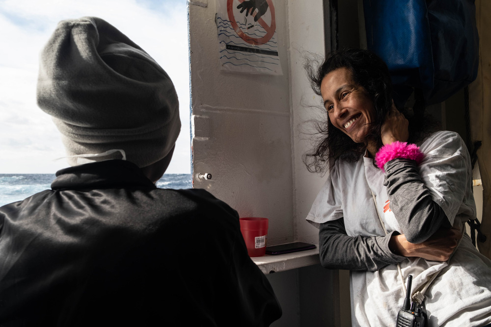 Cultural mediator Nejma talks with survivor Ekesili Emenike on the Geo Barents