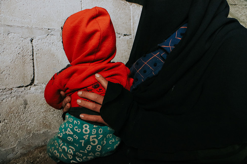 A displaced woman taking care of her son inside her tent in a displaced camp in Idlib governorate, northwest Syria.