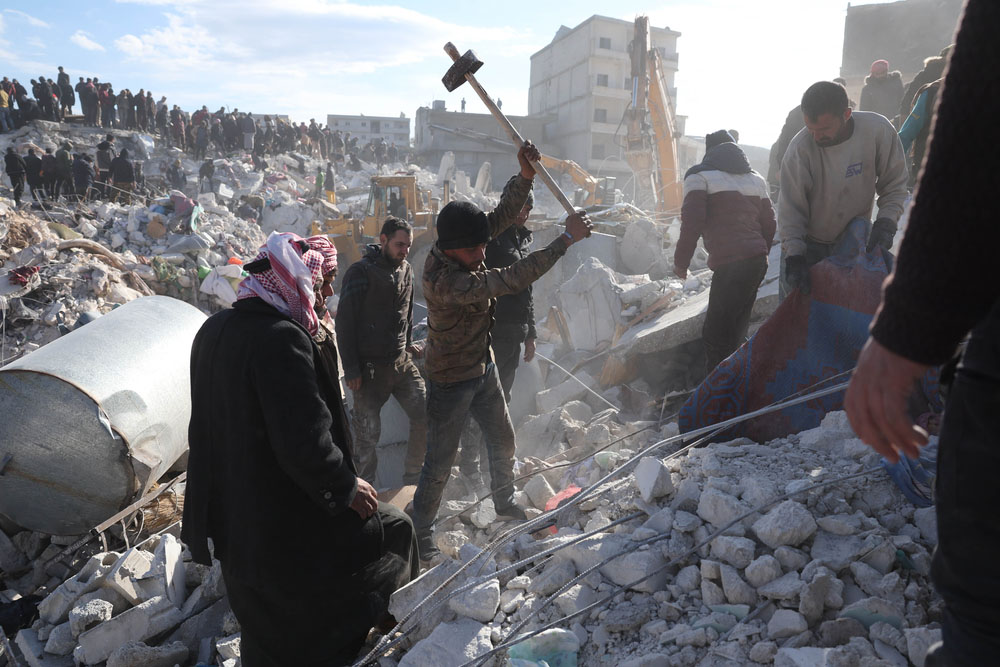 People dig through the rubble of collapsed buildings