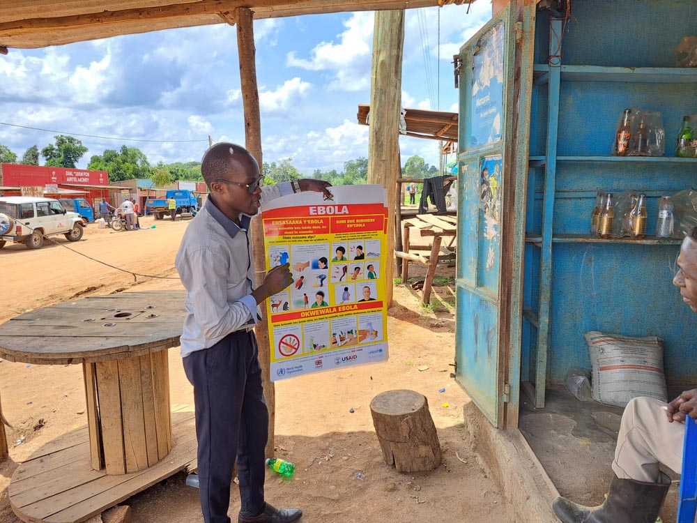 Doctors Without Borders (MSF) health promoter talks with a shop keeper in Madudu