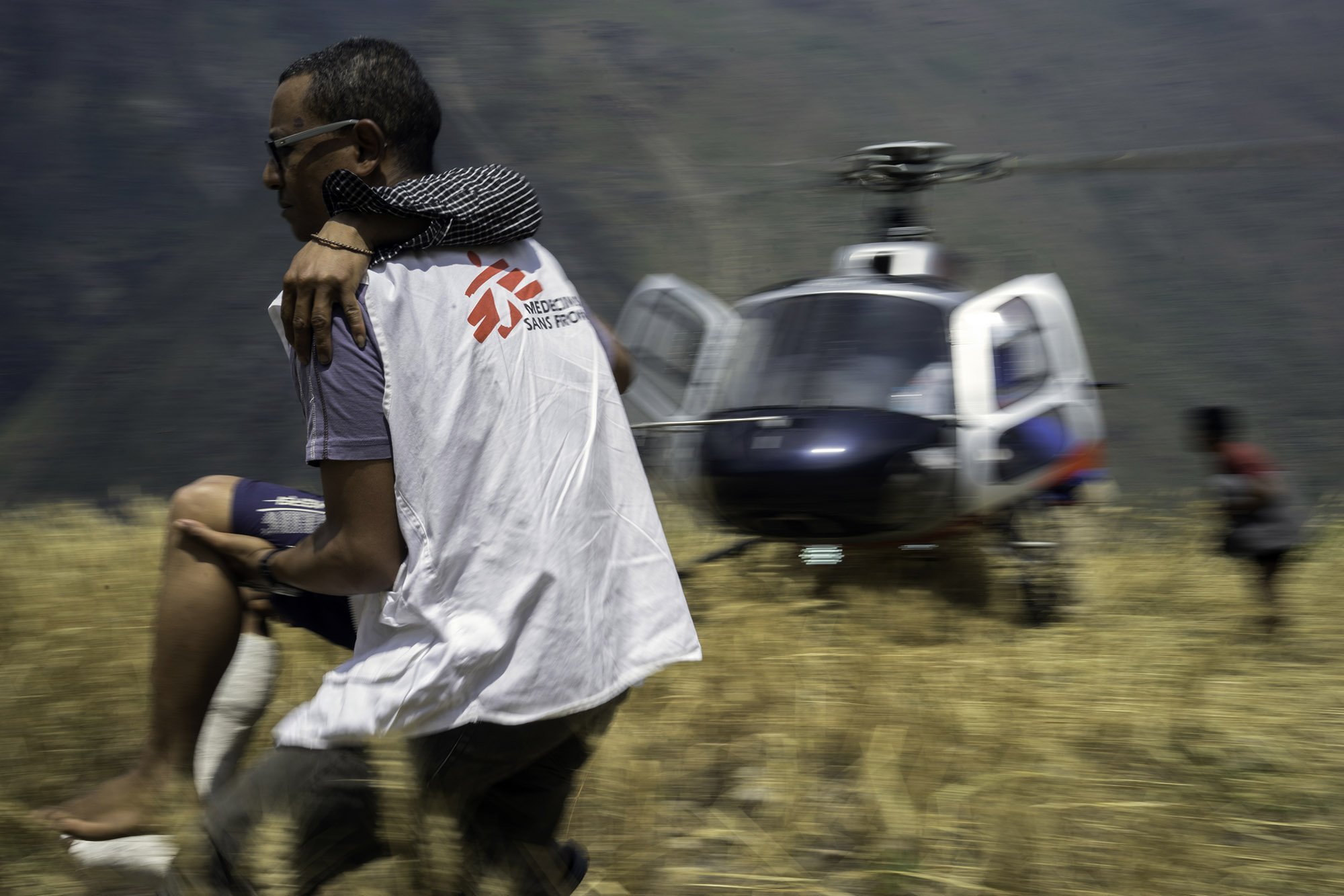 MSF worker carrying injured patient