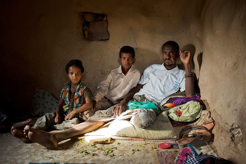 Fadhl Ahmad, a guard for the qat fields, sits with his two sons in his home on July 22, 2015. Fadhl had no work since the recent crisis started in March, 2015, He said “there has been no diesel to pump the water to water the qat, so at the moment I have no work."