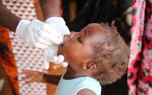 A child receives a new oral vaccine which is much more cost effective and easier to store.