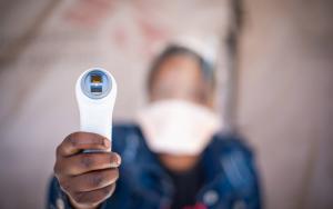 A picture of a healthcare worker holding an infrared themometer