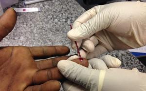 MSF staff member taking out blood for an HIV test