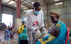 An MSF nurse aide performs the MUAC measurement test on a child at the MSF mobile refugee clinic in Sudan