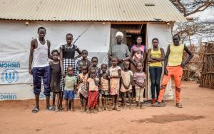 Nyakun Kuok and her family standing outside her house in Dagahaley camp
