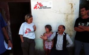 Mobile clinic in Kraijc Kosovo. MSF worker in conversation with man and child. 