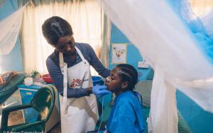 A physiotherapist runs a survivor of Noma, one of the neglected diseases, through her exercises.