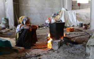 A 15-yearl old displaced girl watching the fire on the concrete flooe