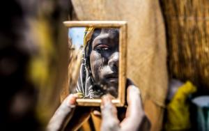 A woman looks into a mirror, depicting perfectly the state of Mental Health in Africa 
