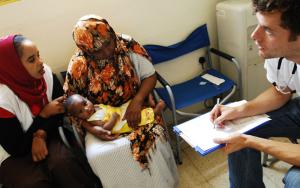Doctor John Hart in consultation with a Somali woman and her baby suffering from a fungal skin infection and the clinic run by MSF near the centres for migrants and asylum seekers in Malta. A cultural mediator translates into the patient's language.
