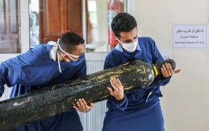 Two MSF staff carrying oxygen tanks