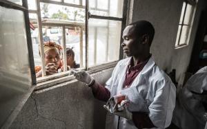Image of an MSF staff member distributing nutritional food in Rusayo, Democratic Republic of Congo
