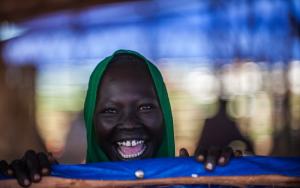 A woman smiling at the camera in Bambasi Camp
