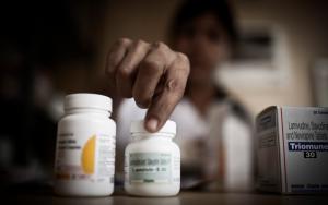 A women checks the labels on bottles of medication. Access to medi