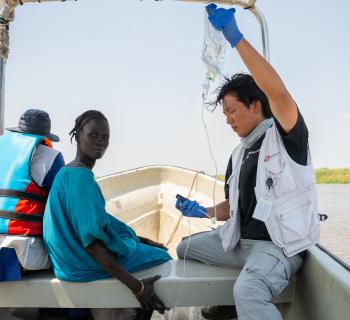 MSF staff member Joon Hyuk holds an IV drip for a patient being referred to Chuil primary healthcare centre , as the patient is transported for further treatment from a mobile clinic in Yakuach.