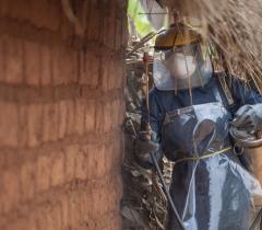 A sprayer is treating a house against mosquitoes during the 2019 indoor residual spraying campaign in Kinyinya health district, Burundi 