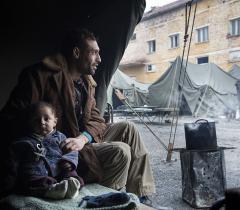 A Syrian man and his infant son sit in their tent at Harmanli Camp, a former military installation in Bulgaria. A major increase in the number of migrants crossing into Bulgaria in recent months has strained Bulgaria's existing system. Authorities have quickly moved migrants into makeshift facilities including abandoned schools, tents, containers and military barracks. 