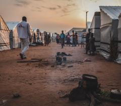 An MSF staff member walks through Mbawa internally displaced people's camp, where most of the displaced were uprooted by the so-called ‘farmer-herdsmen’ conflict. Benue state, Nigeria, June 2020.