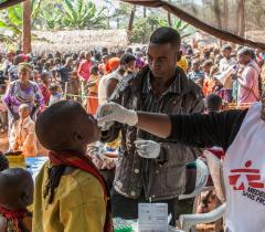 MSF Staff administrating an oral vaccine to a boy at the Nyaragusu refugee camp, Tanzania