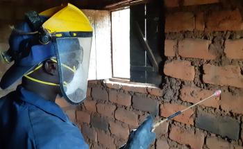 A sprayer is treating a house against mosquitoes during the 2019 indoor residual spraying campaign in Kinyinya health district.