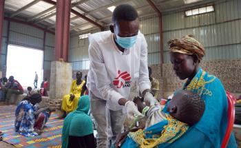 An MSF nurse aide performs the MUAC measurement test on a child at the MSF mobile refugee clinic in Sudan