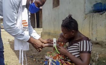 An MSF staff member measuring a child's arm for malnutrition