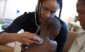 MSF staff member examining a child at Site B Ubuntu Clinic