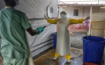 A health worker being disinfected with chlorine at the Ebola treatment center