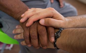 MSF staff and patient holding hands