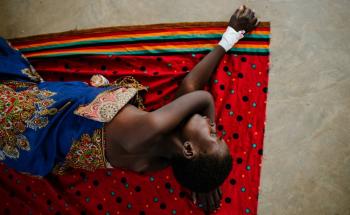 Advanced HIV patient lying on a cloth on the ground