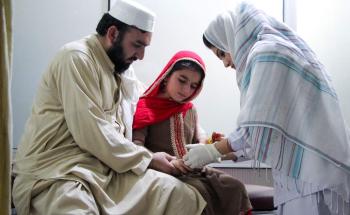 A young patient with her father receiving an injection for cutaneous leishmaniasis in Pakistan