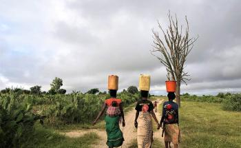 Three women return to their village after collecting water from a water distribution organized by MSF teams in the village of Fenoiva. 