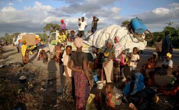 People displaced by the conflict in Cabo Delgado, a northern province in Mozambique, wait next to a truck on the outskirts of Mueda. They had previously been resettled in other areas of the province but are now aiming to reach Palma, a coastal town that was attacked earlier this year and where some people have already gradually returned. 