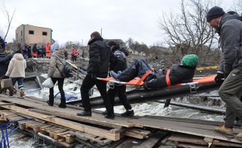 Brancardage d'un vieux monsieur dur passerelle de fortune. 