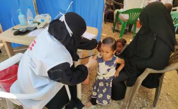 A picture of an MSF staff member giving a child a medical check up