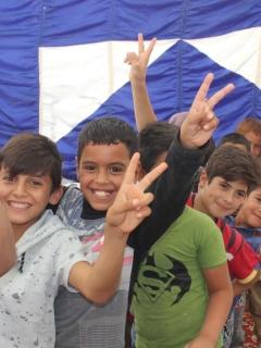 Child health: A group of boys smile and give the peace sign
