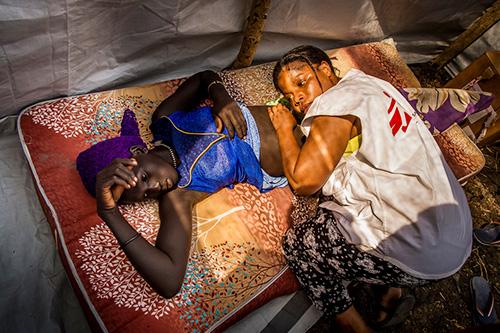 A MSF health worker assisting a patient.