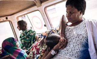 Amatou lies on Odette, a midwife at the Ndu health centre. The MSF ambulance is transferring Amatou to the University Hospital in Bangassou for emergency obstetrics care. Central African Republic 2021