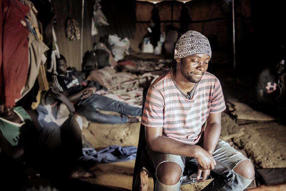 A migrant from the DRC sits in a tent at a temporary shelter for migrants travelling into South Africa.