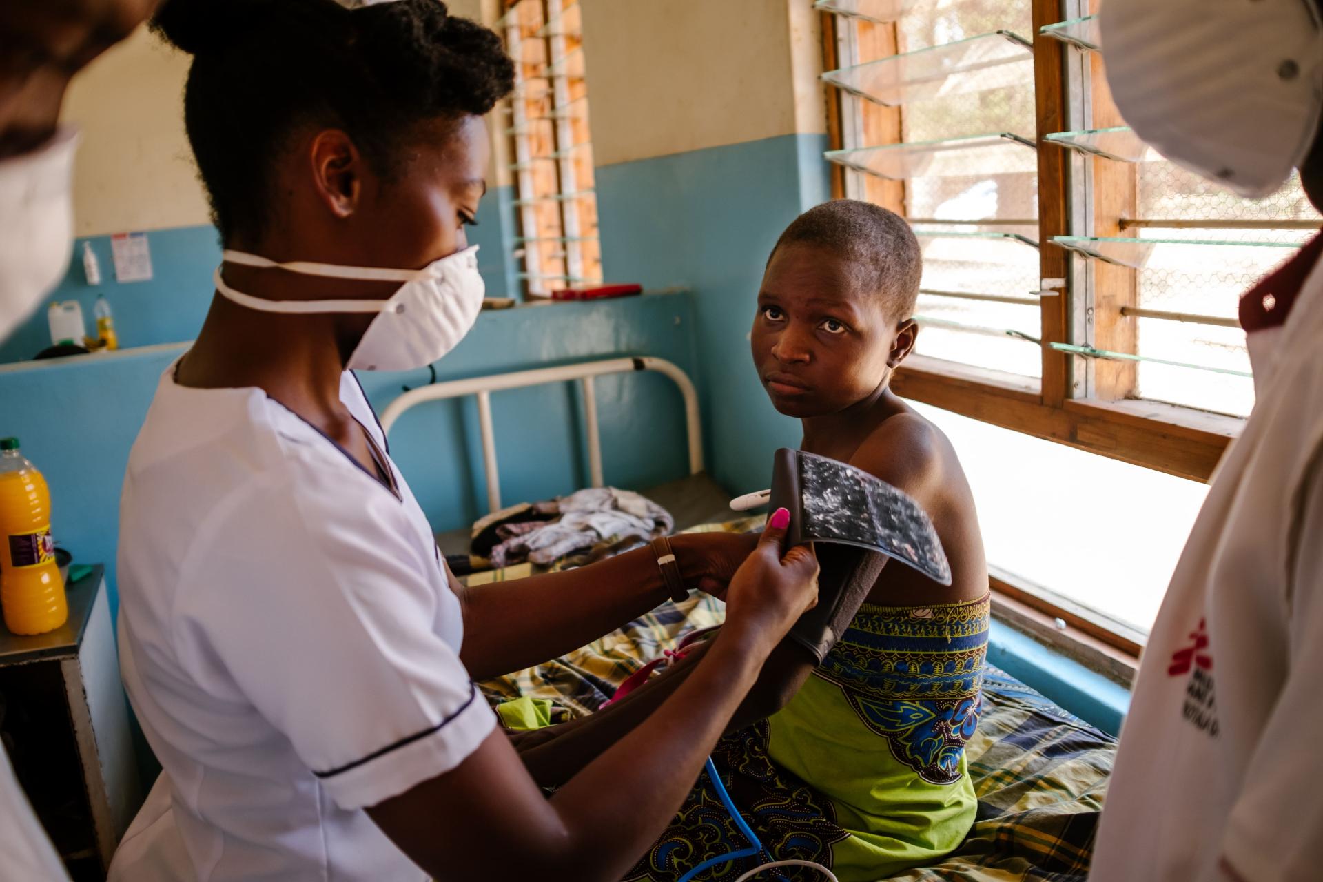 Deborah, MSF Nurse Mentor, is conducting a physical examination for Esther, an advanced HIV patient.