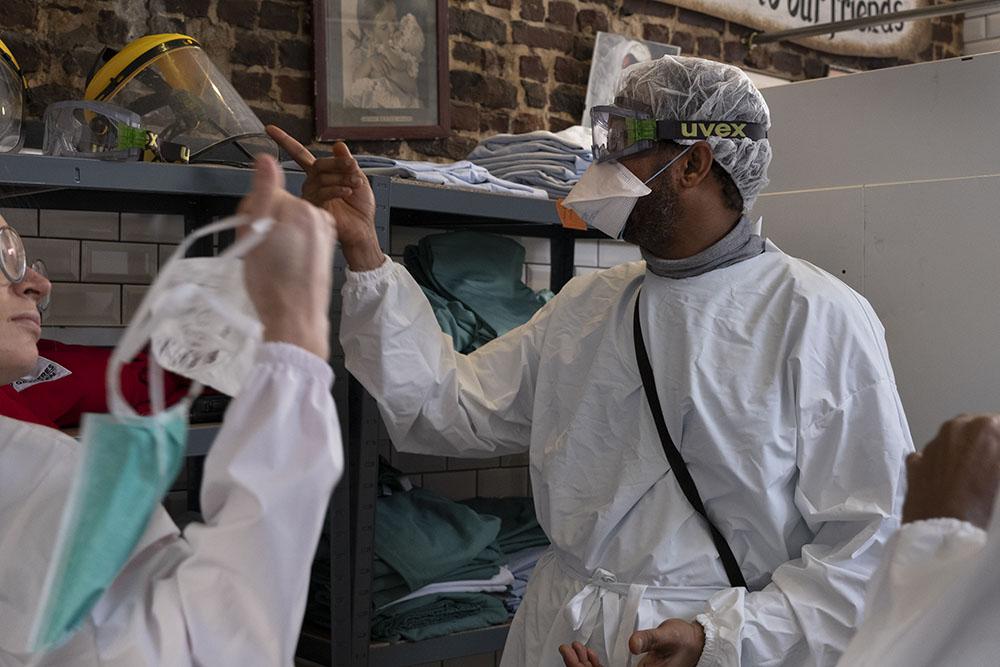 Cultural mediators and medical staff getting dressed with PPE before the medical round. 