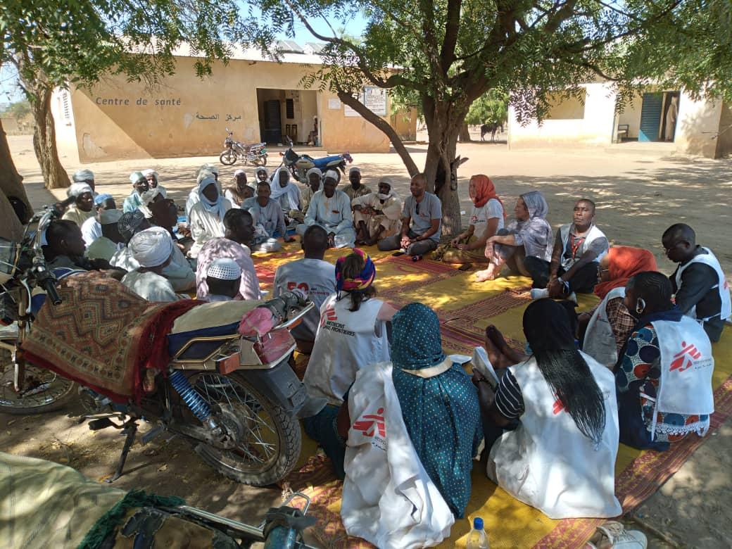 MSF teams sitting in a circle with the community