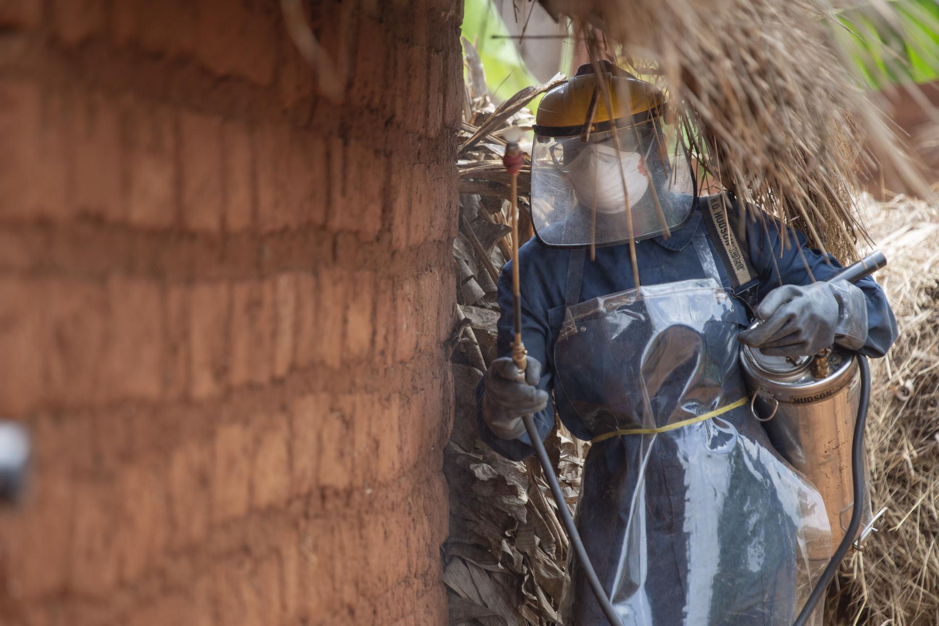 A sprayer is treating a house against mosquitoes during the 2019 indoor residual spraying campaign in Kinyinya health district, Burundi